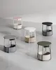A collection of round side tables with built-in power outlets and USB ports, displayed on a concrete floor against a textured wall. Náhled obrázku produktu