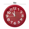 A red analog alarm clock with white numbers and hands, shown against a white background. A measurement line with '12cm' is overlaid at the top. Produktbild-Vorschau