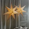 Two star-shaped lamps are displayed on a table in front of a curtain. Podgląd zdjęcia produktu
