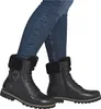 A person wearing blue jeans and black lace-up boots with fur trim. Produktbild-Vorschau