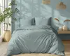 A neatly made bed with mint-colored striped bedding in a room with light blue walls and natural light. Náhled obrázku produktu