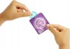 Hands holding a small package with a Barbie logo and a small blue accessory. Náhľad obrázku produktu