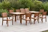 A wooden garden furniture set with a table and chairs is arranged on a patio, with greenery in the background. Produktbild-Vorschau
