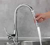 A hand is holding a flexible faucet extender with water flowing from it into a sink. Produktbild-Vorschau