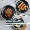 Three frying pans with food on a marble-like surface. Produktbild-Vorschau