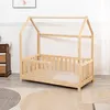 A wooden toddler bed with a house-shaped frame is shown in a room with a patterned rug and a dresser in the background. Anteprima dell’immagine prodotto