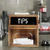 A wooden suggestion box with a chalkboard top labeled "TIPS" sits on a counter, with envelopes inside and a bell to the side. Náhled obrázku produktu