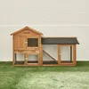 A wooden rabbit hutch is displayed on a patch of artificial grass in front of a white brick wall. Produktbild-Vorschau