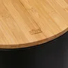 Close-up of the top of a black trash can with a bamboo lid, showing the brand logo. Náhľad obrázku produktu