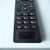 A close-up view of a black remote control with various buttons. Produktbild-Vorschau