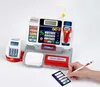 A toy cash register with accessories and a hand holding a pen and cards. Produktbild-Vorschau