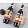 Two wine bottles are displayed on a textured surface with a pine cone nearby. Produktbild-Vorschau