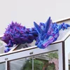 A 3D printed crystal dragon figurine rests on the edge of a clear-sided display case. Produktbild-Vorschau