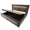 A bed frame with its storage compartment open and the mattress support lifted to reveal the storage space. Produktbild-Vorschau