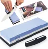 A knife sharpening stone set with a knife being sharpened, a box, and a knife holder. Produktbild-Vorschau