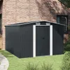 A dark gray metal shed with white trim is situated on a green lawn next to a brick building. Náhled obrázku produktu