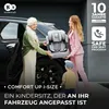 Two women and a child are placing a car seat into a car. Produktbild-Vorschau