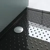 A close-up view of a black shower tray with a silver drain cover and a textured surface. Produktbild-Vorschau