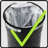 A close-up view of the inside of a black trash can with a white plastic liner, overlaid with a large green checkmark. Produktbild-Vorschau