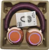 Headphones are placed in a cardboard insert within a box. Voir les images du produit