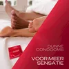 Close-up of two people's feet in bed, with a Durex condom wrapper in the foreground and marketing text on a red overlay. Náhled obrázku produktu