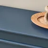 A close-up view of a blue cabinet with a wooden tray and decorative objects on top. Náhľad obrázku produktu