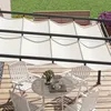 An outdoor patio scene with a pergola, table, and chairs. Podgląd zdjęcia produktu