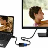 A laptop is connected to a larger monitor via an adapter and cables. Produktbild-Vorschau