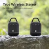 Two black portable Bluetooth speakers are placed on a rock with a blurred green background. Voir les images du produit