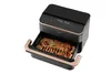 A black and gold air fryer with a rack of roasted meat and vegetables pulled out. Produktbild-Vorschau