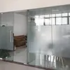 A view through a glass door into an office space with a sofa and chairs. Voir les images du produit