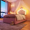 A child's bedroom with a pink bed, teddy bear, and city view outside the window. Produktbild-Vorschau