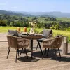 A patio furniture set with a round table and four chairs is set up on a wooden deck, with a scenic view of rolling green hills and mountains in the background. Náhled obrázku produktu