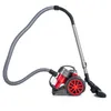 A compact, bagless cylinder vacuum cleaner with a red dustbin and red wheel accents, shown against a white background. The vacuum features a flexible grey hose connected to a telescopic metal wand and a floor nozzle. Anteprima dell’immagine prodotto