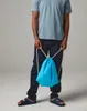 A person is holding a blue drawstring bag. Produktbild-Vorschau