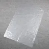 A clear plastic garment bag lying flat on a textured gray surface. Anteprima dell’immagine prodotto