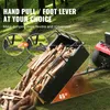 A trailer filled with firewood is being dumped by a lawn tractor in a grassy, wooded area. Produktbild-Vorschau