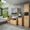 A modern bathroom with wooden vanity units, a sink, a mirror, and a tall cabinet, set against a concrete wall and a large window overlooking a lush green forest. Produktbild-Vorschau