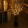 Decorative LED branches in a vase, placed on a wooden floor next to a bookshelf. Náhled obrázku produktu