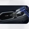 A close-up shot of a blue handheld vacuum cleaner being used to clean the air vents of a car's dashboard. Náhled obrázku produktu