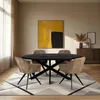 A dining room scene with an oval dining table and chairs, set on a rug with a large abstract painting on the wall. Voir les images du produit