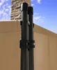 A close-up view of a beige fabric screen attached to two black poles, with a brick wall and blue sky in the background. Produktbild-Vorschau