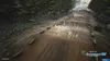 A dirt track with trees on the sides, and barriers with the Monster Energy logo on them. Produktbild-Vorschau