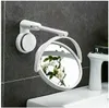 A white makeup mirror is mounted on a gray tiled wall above a white sink. Produktbild-Vorschau