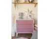 A dresser with pink drawers is decorated with a lamp, a star decoration, and a vase with pampas grass. Voir les images du produit