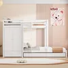 A white bunk bed with a wardrobe and a pull-out bed, set against a pastel pink and cream wall with a cartoon bear poster. Produktbild-Vorschau