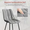 A close-up of a gray upholstered chair with text overlays and diagrams highlighting its features. Produktbild-Vorschau