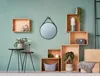A collection of wooden storage boxes and decorative items arranged on a light green wall. Produktbild-Vorschau