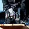A person wearing work gloves is using a cordless drill to drill into a piece of wood. Anteprima dell’immagine prodotto