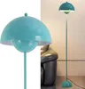 A collage showing a close-up of a turquoise floor lamp and a full shot of the same lamp in a room next to a black leather sofa. Voir les images du produit